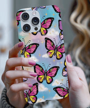 A dreamy phone case featuring pink and yellow butterflies with black outlines flying across a pastel sky background with fluffy clouds and sparkling gold stars.