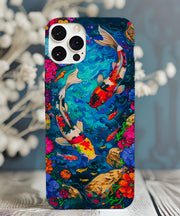 A vivid koi fish phone case featuring two colorful koi swimming in a bright blue pond surrounded by vibrant flowers, rocks, and swirling water patterns in a fantasy-inspired style.