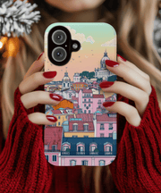 A pastel-toned phone case featuring a dreamy Lisbon cityscape with colorful rooftops, domed churches, and sunset skies in soft peach, mint, and pink hues, blending architecture and art in a whimsical travel aesthetic.