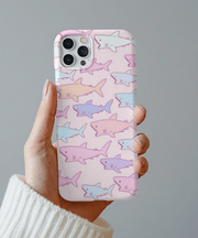 Cute pastel phone case covered in hand-drawn shark illustrations in soft pink, lavender, and blue tones. The kawaii pattern adds a playful ocean vibe, perfect for anyone who loves cute sea creatures and pastel aesthetics.