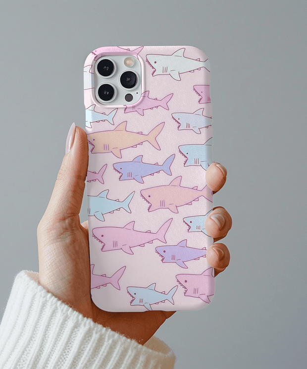 Cute pastel phone case covered in hand-drawn shark illustrations in soft pink, lavender, and blue tones. The kawaii pattern adds a playful ocean vibe, perfect for anyone who loves cute sea creatures and pastel aesthetics.