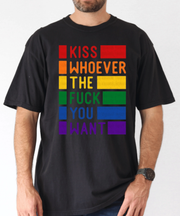 A black oversized t-shirt with bold rainbow block text reading “Kiss Whoever the F*ck You Want,” celebrating LGBTQ+ pride and freedom of love in a vibrant, unapologetic statement design.