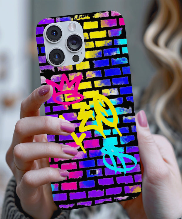 A bold phone case featuring vibrant graffiti-style “LEO” lettering in yellow, with a pink crown and teal symbol on a colorful brick wall background in neon blue, purple, and yellow tones.