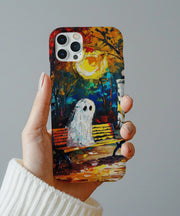 A moody autumn phone case showing a ghost sitting alone on a park bench beneath a glowing moon and colorful fall trees. The painterly brushstroke texture creates a dreamy, melancholy atmosphere.