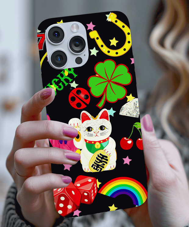A black phone case decorated with vibrant lucky symbols including a maneki-neko cat, four-leaf clover, horseshoe, rainbow, cherries, dice, stars, and ladybug. The bold design pops with color and good fortune vibes.