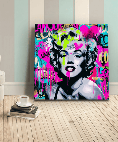 A bold graffiti-style canvas featuring a modern pop art portrait of Marilyn Monroe. The artwork blends neon pink, turquoise, yellow, and black spray-paint textures with graffiti lettering and street art hearts for an edgy, urban aesthetic.