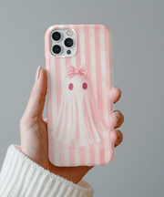 Soft pink phone case with a cute ghost wearing a matching bow, set against a pastel pink striped background.  The design blends kawaii and coquette aesthetics, perfect for fans of pastel goth, girly spooky vibes, and soft pink accessories.