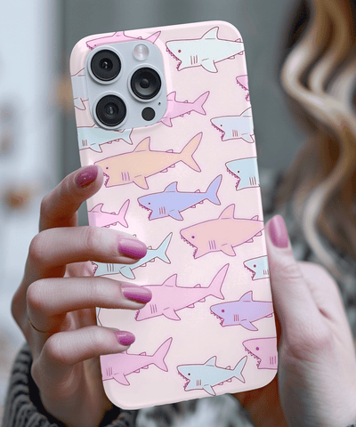 Cute pastel phone case covered in hand-drawn shark illustrations in soft pink, lavender, and blue tones. The kawaii pattern adds a playful ocean vibe, perfect for anyone who loves cute sea creatures and pastel aesthetics.