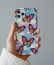 A dreamy phone case featuring pink and yellow butterflies with black outlines flying across a pastel sky background with fluffy clouds and sparkling gold stars.