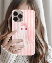 Soft pink phone case with a cute ghost wearing a matching bow, set against a pastel pink striped background.  The design blends kawaii and coquette aesthetics, perfect for fans of pastel goth, girly spooky vibes, and soft pink accessories.