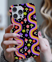 Colorful retro phone case featuring rainbow wavy lines, smiley face mushrooms, and bright flowers on a black background. Funky 70s-inspired psychedelic design with pink, purple, yellow, and green accents, perfect for groovy vintage lovers and bold aesthetics.