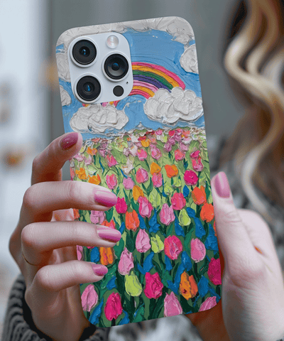 Phone case featuring a textured oil painting design of a vibrant tulip field under a blue sky with fluffy white clouds and a rainbow. The colorful brushstroke pattern in pink, orange, and green creates a cheerful, artistic spring aesthetic.