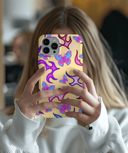 Trendy Y2K-inspired phone case featuring bright pink and blue butterflies surrounded by purple and magenta flame shapes on a soft beige background. A bold, nostalgic design perfect for butterfly lovers and retro aesthetic fans.