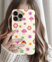 Beige phone case featuring a playful retro pattern of pink mushrooms and colorful flowers in orange, green, blue, and red. Soft pastel design with 70s-inspired charm, perfect for cottagecore lovers and fans of cute, whimsical aesthetics.
