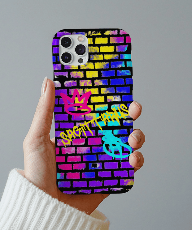 Colorful Sagittarius phone case featuring neon graffiti lettering on a vibrant brick wall background with pink, yellow, blue, and purple spray paint textures. Includes graffiti-style zodiac symbols, perfect for astrology fans who love bold urban streetwear vibes.
