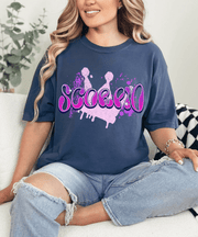 Navy blue oversized t-shirt with bold purple and pink airbrush-style lettering that spells “Scorpio.” The design features paint splatters and a grunge background, perfect for astrology lovers and Scorpio zodiac fans who love edgy, retro streetwear style.