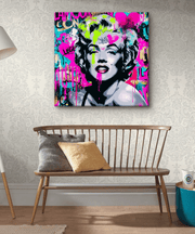 A bold graffiti-style canvas featuring a modern pop art portrait of Marilyn Monroe. The artwork blends neon pink, turquoise, yellow, and black spray-paint textures with graffiti lettering and street art hearts for an edgy, urban aesthetic.