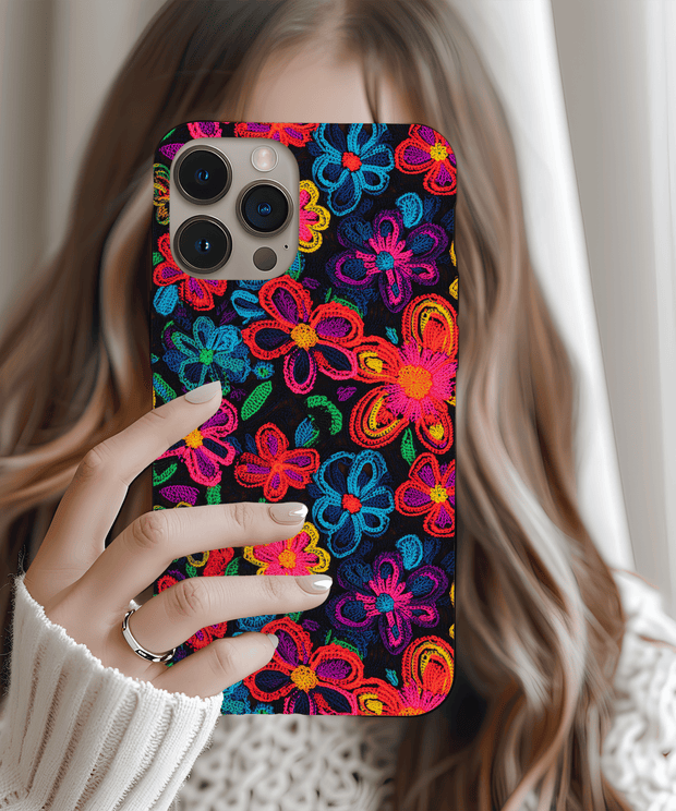 Phone case with a black background covered in vibrant neon embroidered-style flowers in pink, blue, yellow, orange, green, and purple. The colorful design mimics stitched thread for a textured, bold, and artistic look.